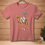 Camel with dripping white substance, umbrella, and patterned saddle on coral t-shirt.