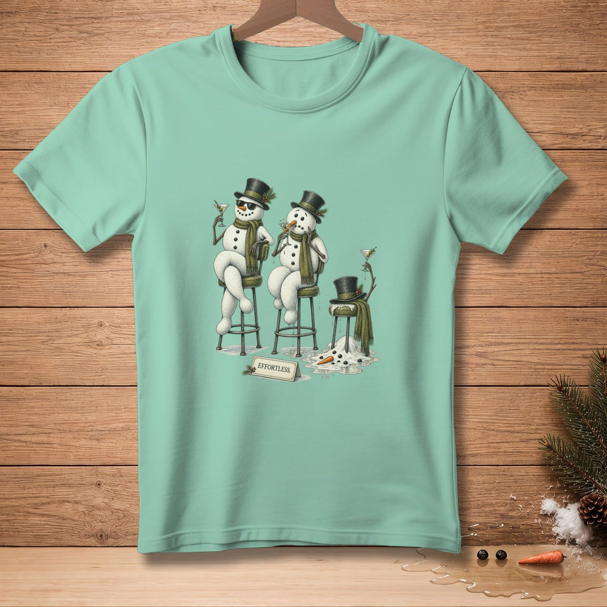 T-shirt with melting snowmen with hats and drinks, and "EFFORTLESS" sign.