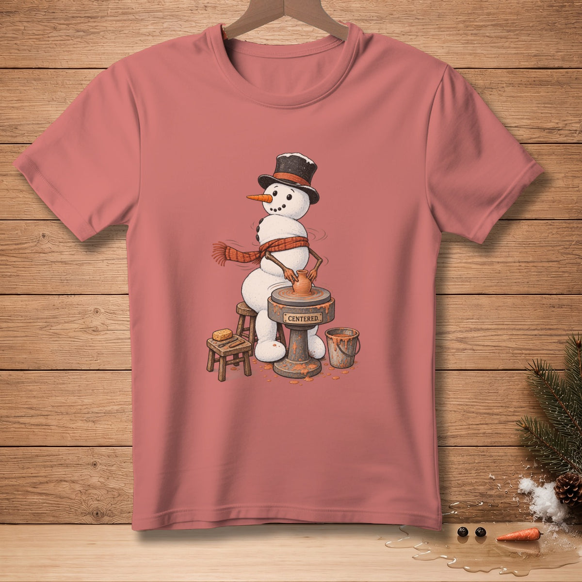 Snowman with hat and scarf making pottery on a wheel with the word "CENTERED."