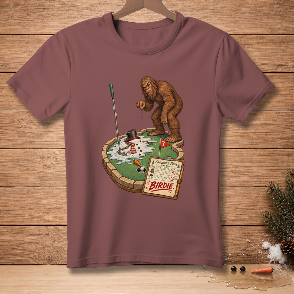 Bigfoot plays mini golf on a snowman-themed course, with a scorecard reading "Sasquatch Pines Birdie".