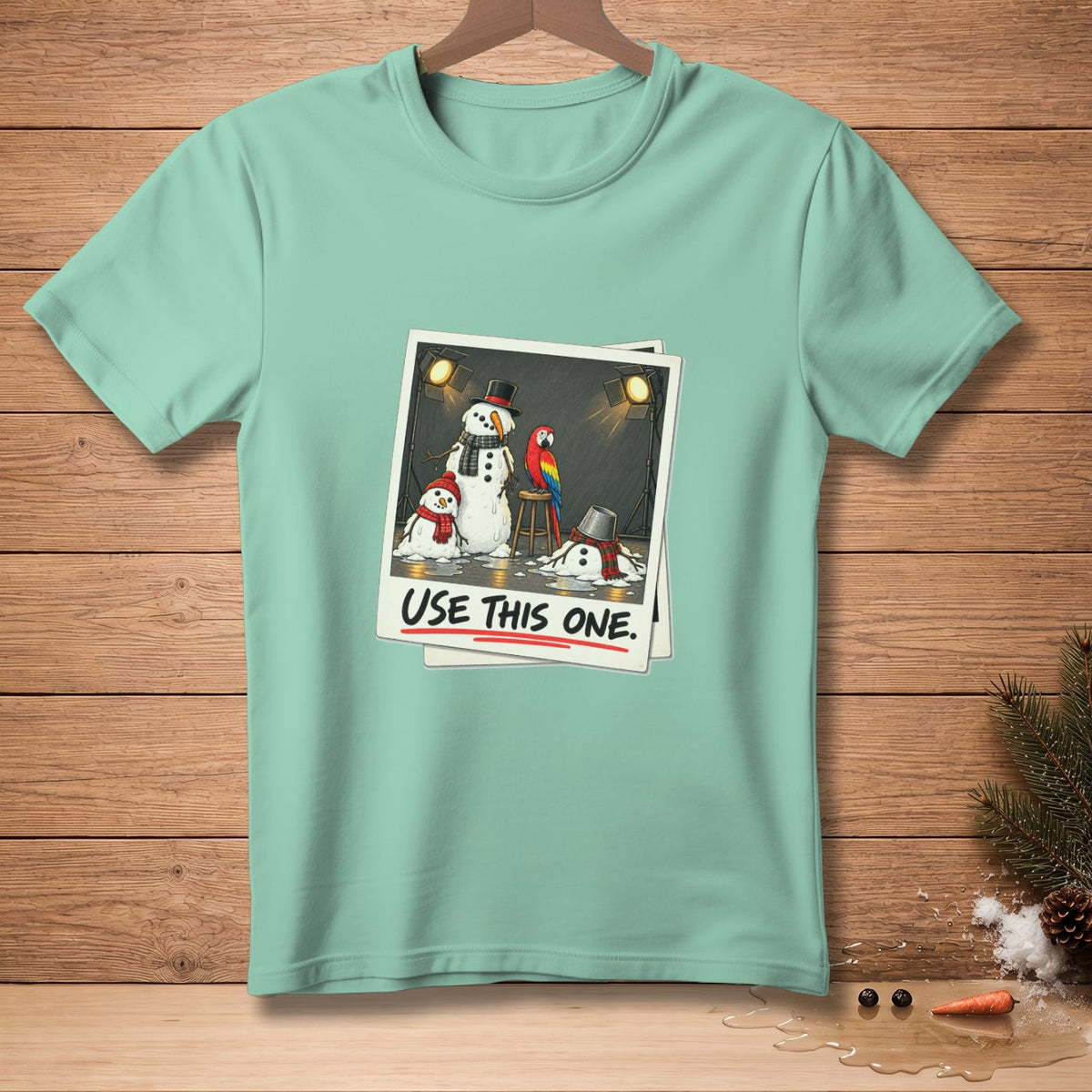 T-shirt with illustration of melting snowmen and parrot, text "USE THIS ONE."