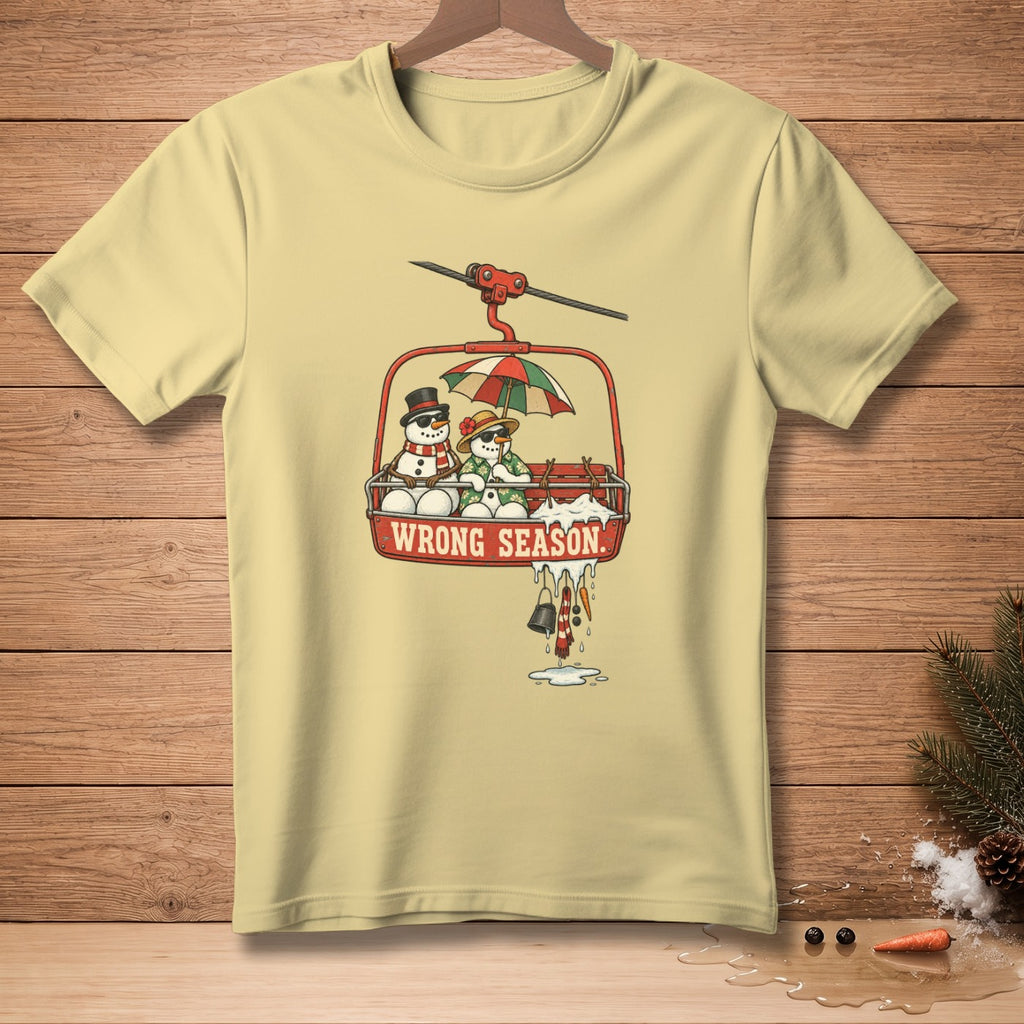 Light yellow t-shirt with snowmen on a ski lift with "WRONG SEASON" text.