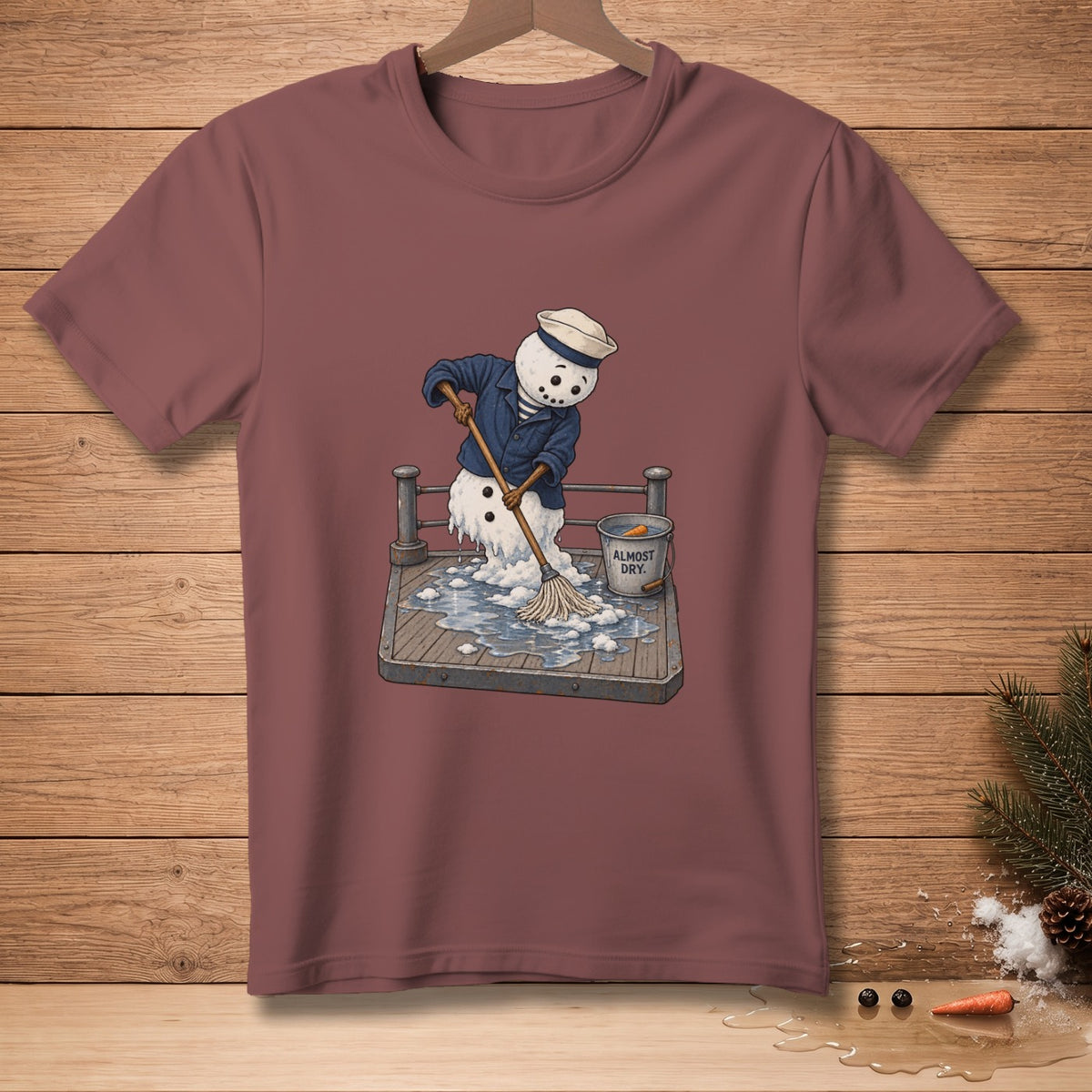 Melting snowman in sailor outfit mops a wet deck; bucket reads "Almost Dry."
