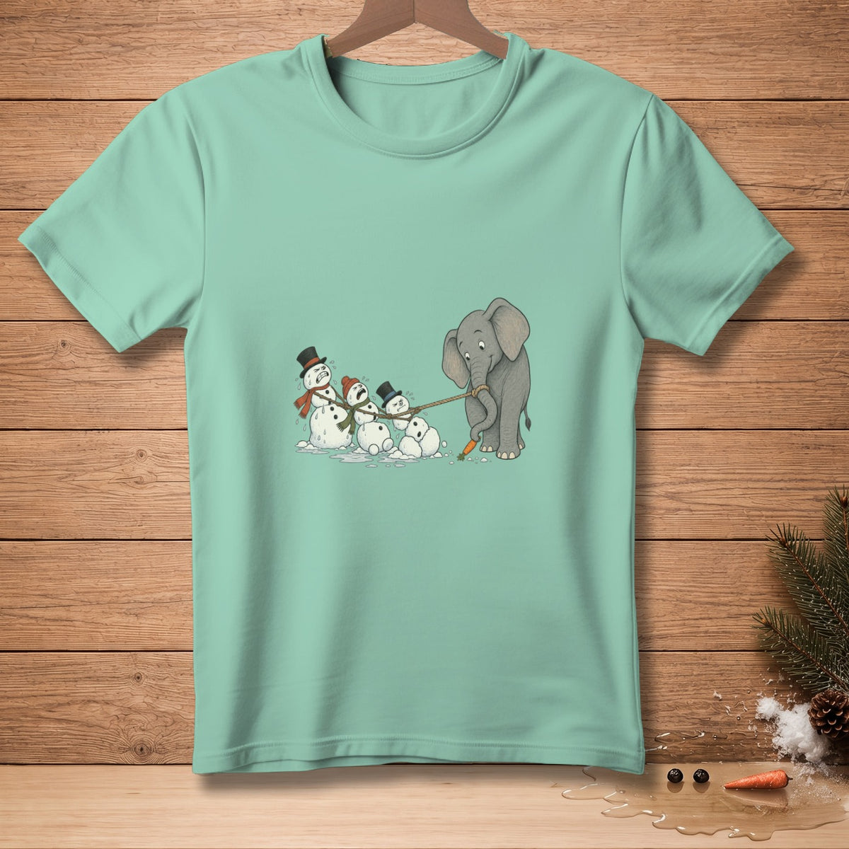 Elephant pulling snowmen with a rope on a light teal t-shirt.