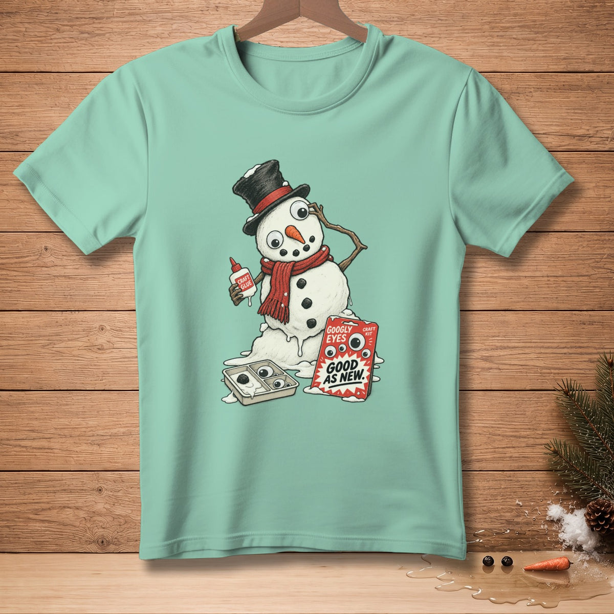 Snowman with glue and googly eyes, on a teal t-shirt.