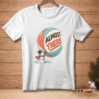 White t-shirt with melting snowman drinking from a ball that says "ALMOST THERE".