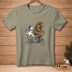 Bigfoot rides a tandem bicycle with a melting snowman, with text "I'M HELPING".