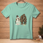 T-shirt graphic of melting snowman and Bigfoot sitting on bench eating ice cream.