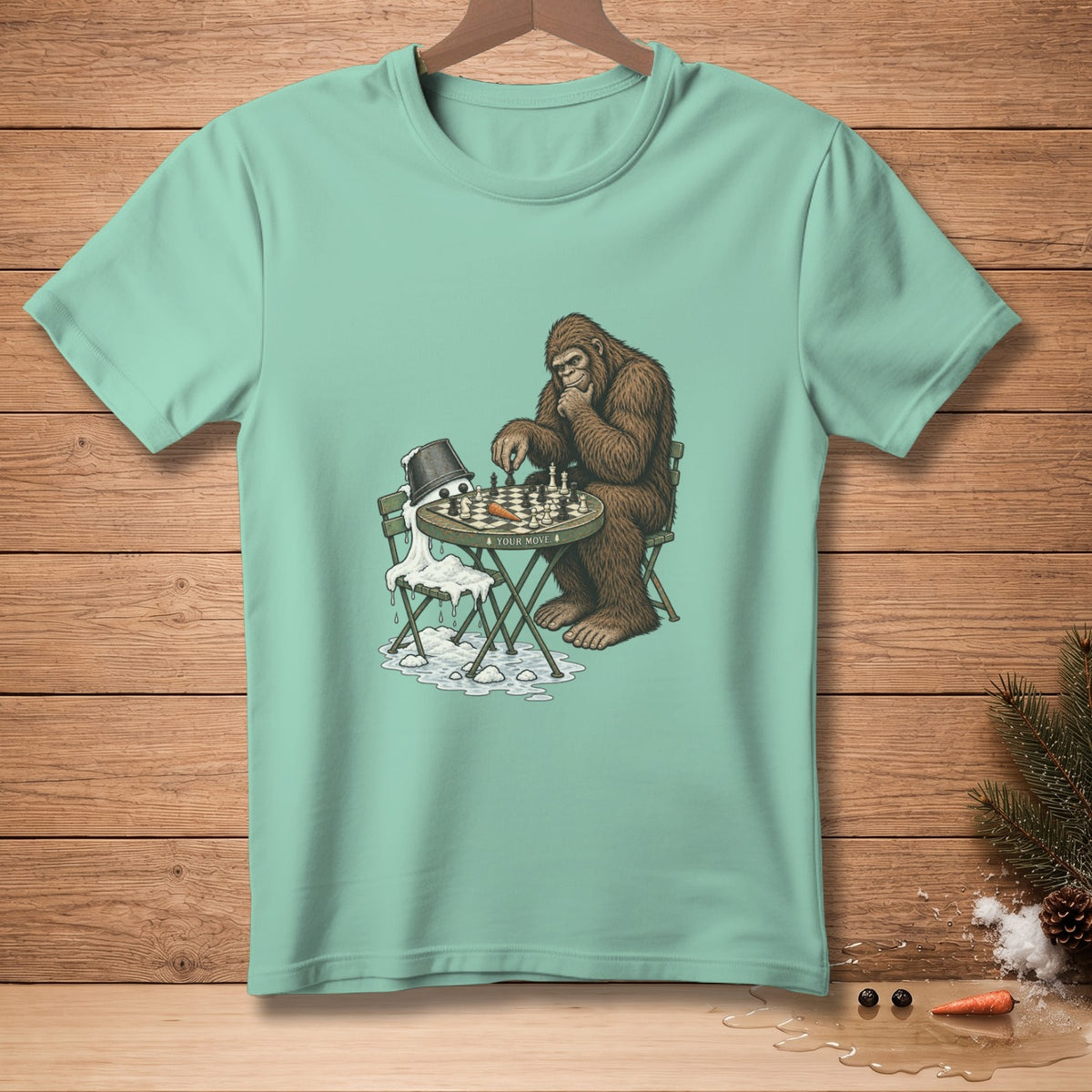 Bigfoot plays chess against a melting snowman on a t-shirt.