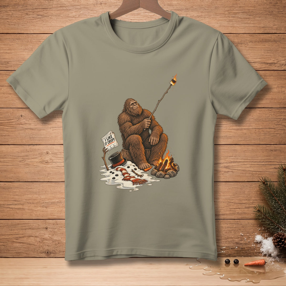 Bigfoot roasts a marshmallow over a campfire, holding a sign that says "I like it crispy."