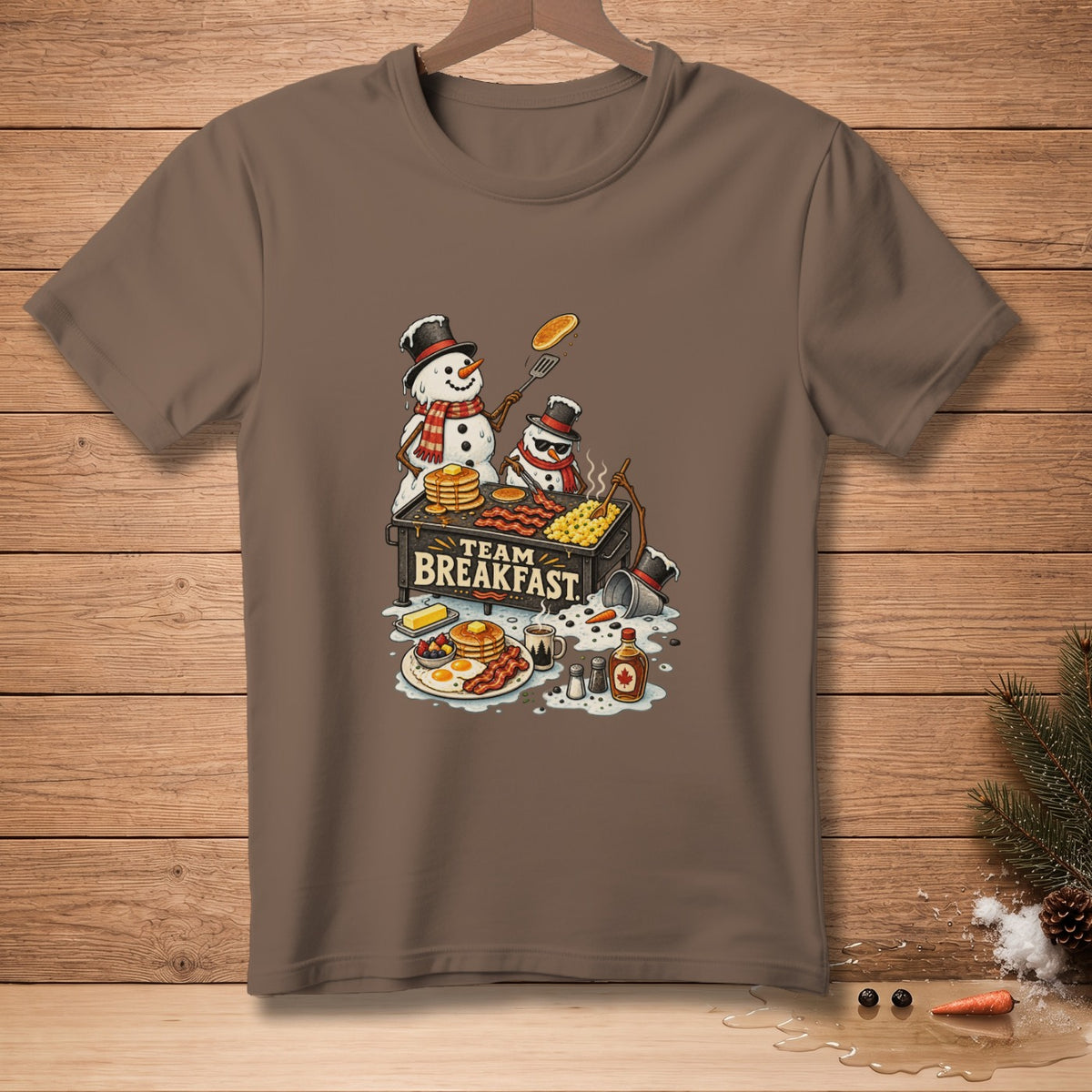 Two snowmen make breakfast with pancakes, bacon, and eggs on a griddle labeled "Team Breakfast."