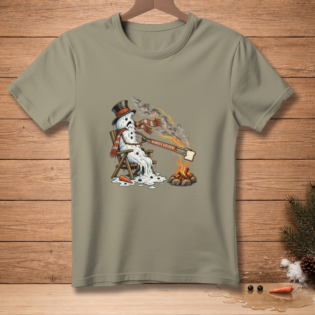 Melting snowman sitting by campfire toasting bread with text "ALMOST GOLDEN."