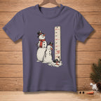 Two melting snowmen stand next to a height chart, one with a red scarf.