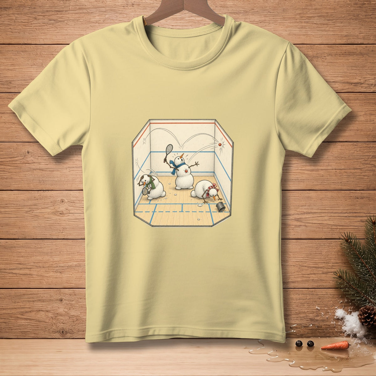 Light yellow t-shirt featuring cartoon snowmen playing squash inside a court.