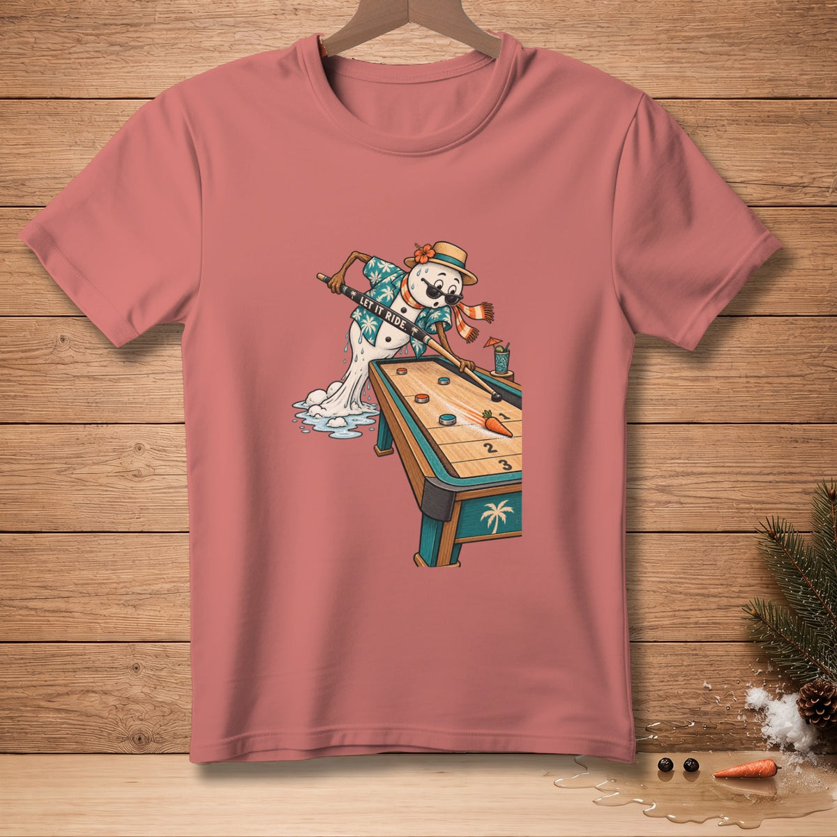 Snowman playing shuffleboard with text "LET IT RIDE" on a pink t-shirt.