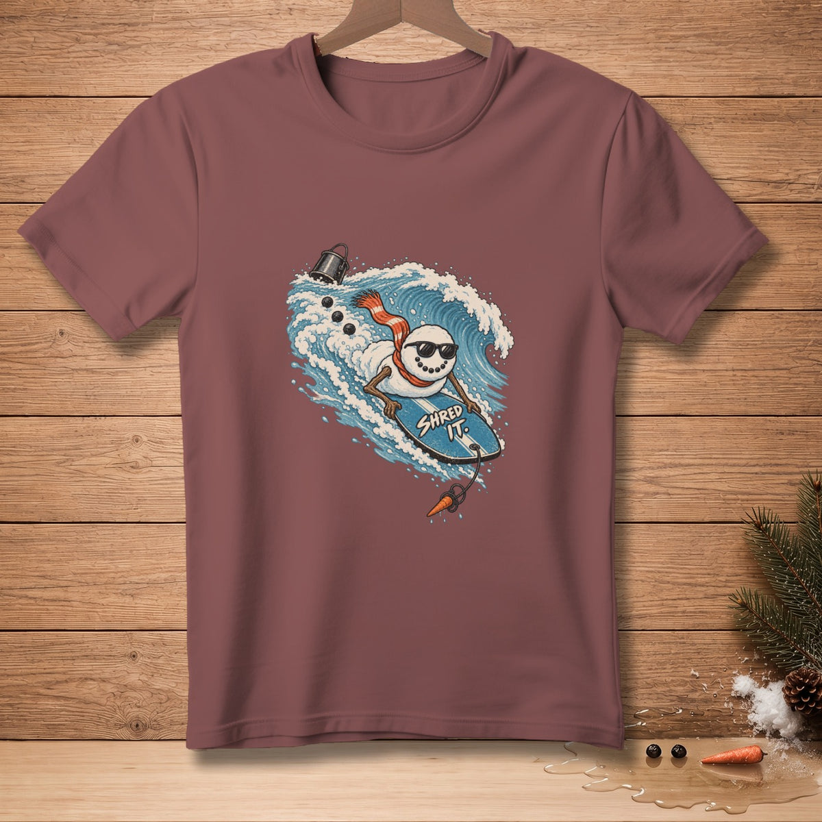 Snowman surfing a wave on a surfboard with "Shred It" text.