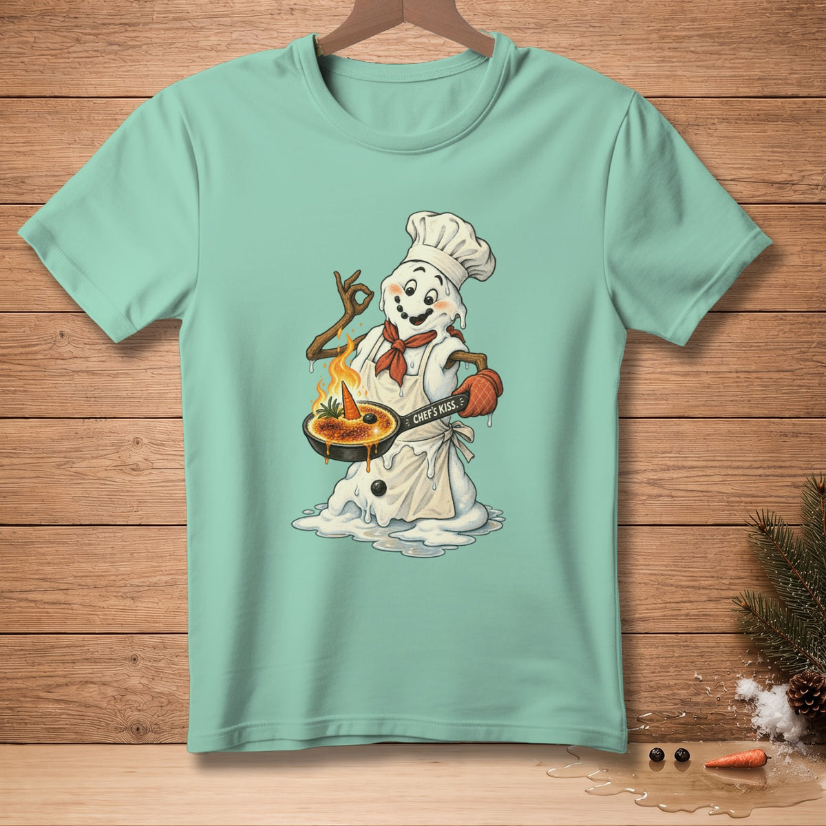 Snowman chef with creme brûlée and "Chef's Kiss" text on a light teal t-shirt.