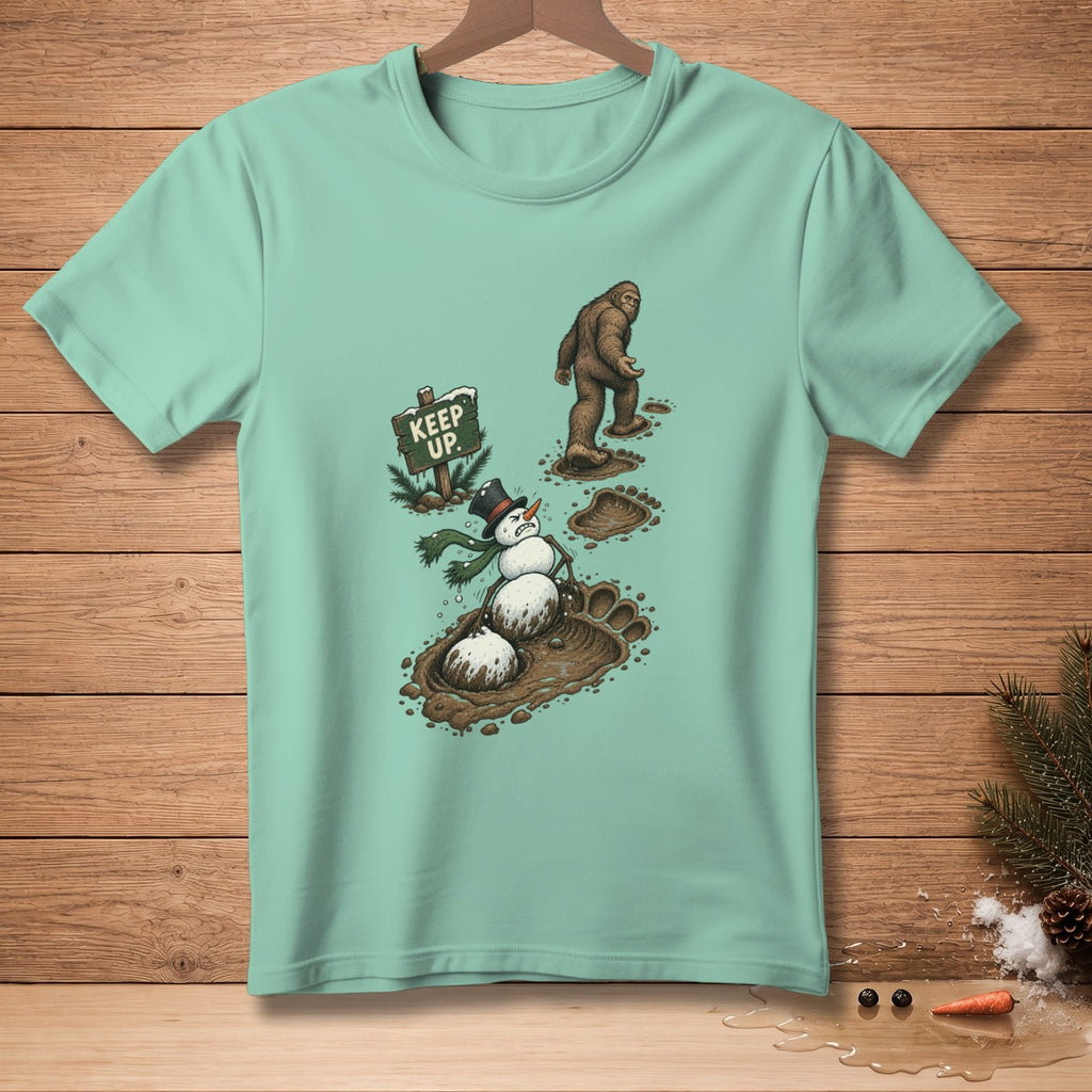 Bigfoot walking past a snowman in mud next to a "Keep Up" sign.