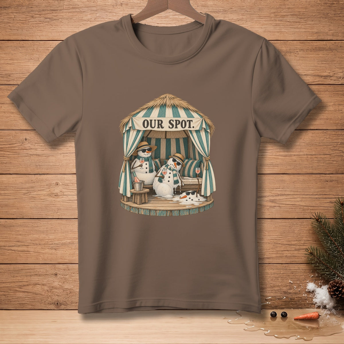 Brown t-shirt with illustration of two snowmen relaxing under a hut with text "OUR SPOT".