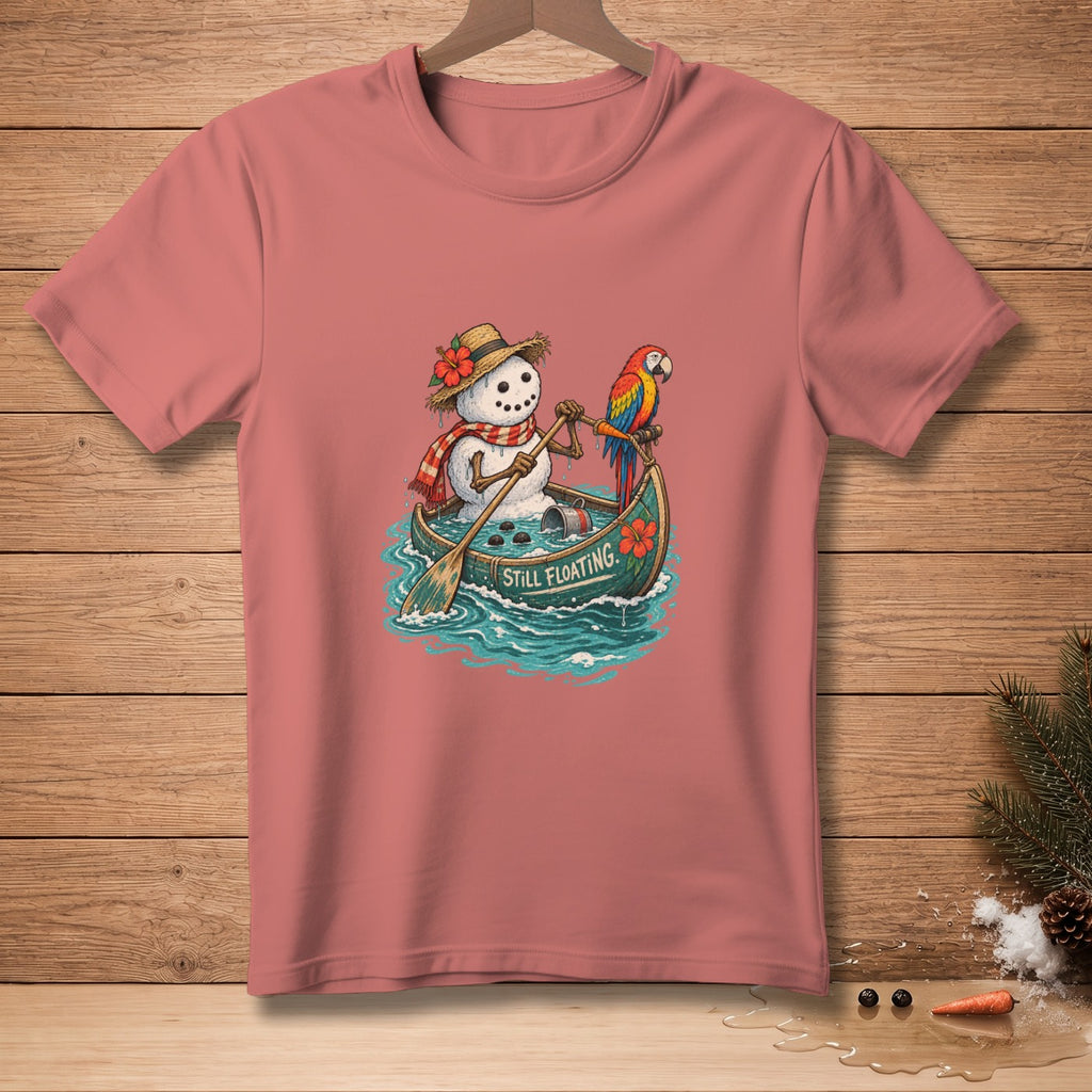 Snowman in a canoe with a parrot, text "STILL FLOATING" on shirt.