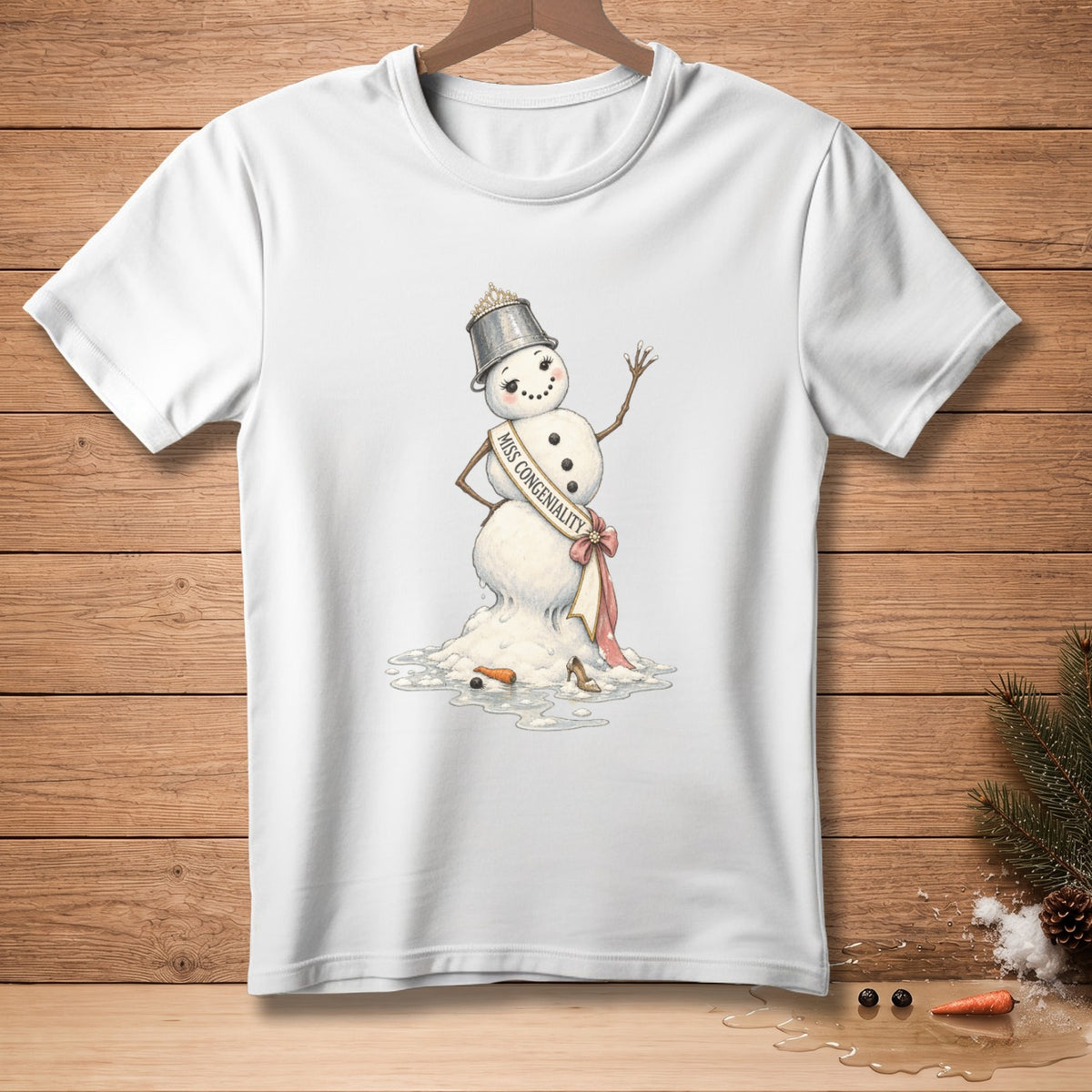 White t-shirt featuring a melting snowman with "Miss Congeniality" sash and crown.