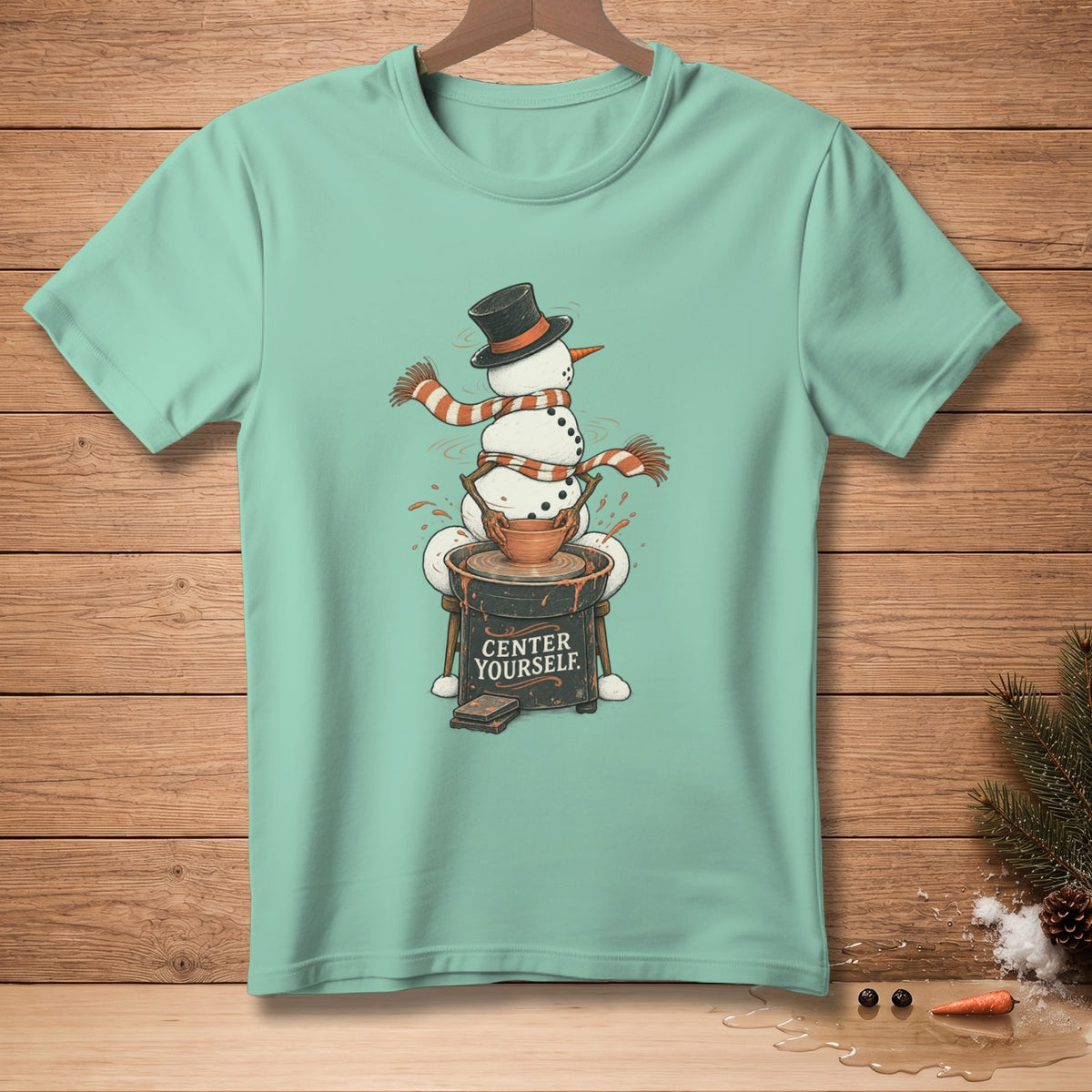Snowman wearing hat and scarf on pottery wheel with text "CENTER YOURSELF."