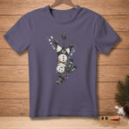 T-shirt with a cartoon snowman zip-lining upside down, wearing a harness.