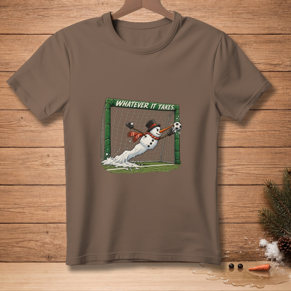 T-shirt with snowman goalie saving soccer ball, "WHATEVER IT TAKES" text.