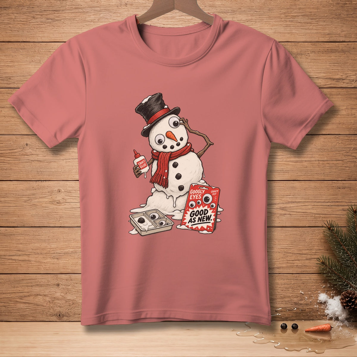 T-shirt with melting snowman holding glue and a craft kit labeled "Googly Eyes Good As New".