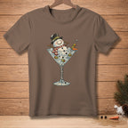 Snowman in martini glass with olives, carrot, and "GENIUS" text on brown t-shirt.