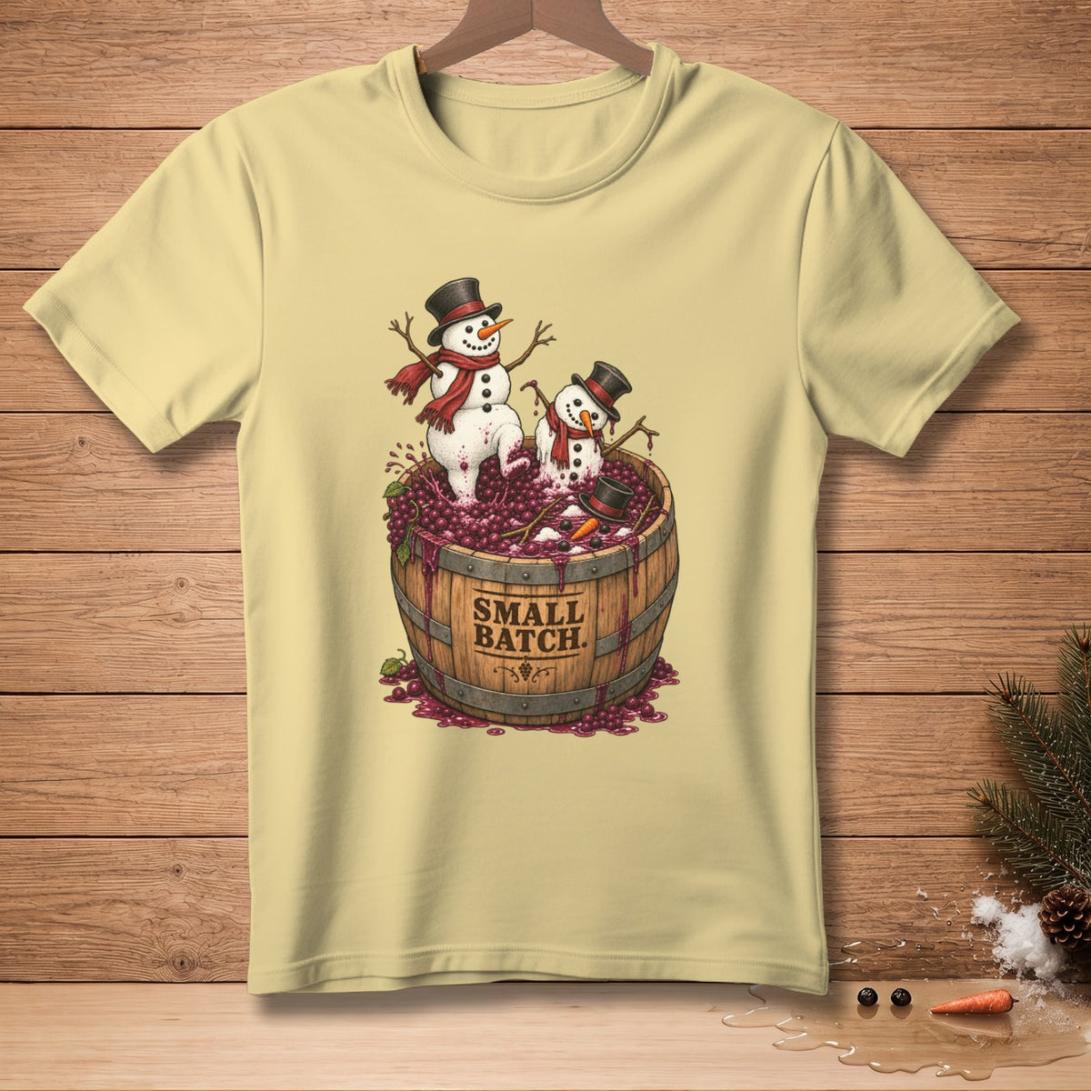 Light yellow t-shirt with cartoon snowmen in a barrel of grapes, reading "Small Batch".