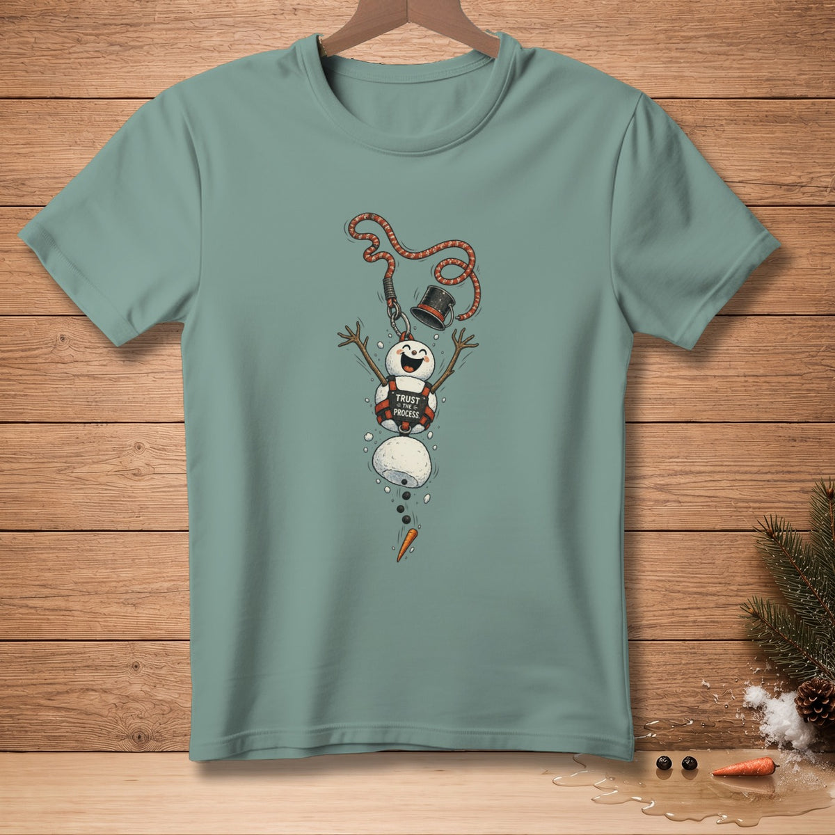 T-shirt graphic of melting snowman with hat, rope, and "Trust the Process" text.